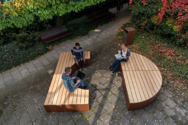 euroform w - arredo urbano - panchina in legno con schienale - seduta modulare nel cortile - gruppo di persone seduti su isole di seduta in legno e acciaio - Isola