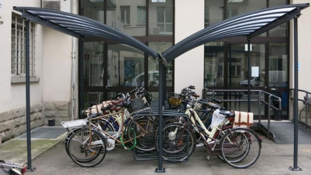 euroform w - Stadtmobiliar - Fahrradständer mit Überdachung bei Wohnkomplex - Wing Bike Fahrraddepot - Fahrradüberdachung aus Glas und Metall