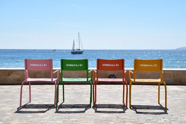 euroform w - Stadtmobiliar - Personen sitzen auf minimalistischen Stühle und Hocker aus Metall entlang Promenade Le Lavandou Cote d