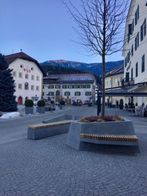 euroform w - Stadtmobiliar - minimalistische Sitzbank aus Holz mit Pflanzschale aus Beton auf öffentlichem Platz - Parkbank Holz für Städte - Designermöbel für draußen - personalisierte Bank