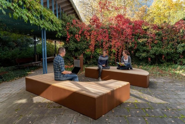 euroform w - urban furniture - wooden parkbench without backrest - wooden modular seating - people sitting on modular bench in courtyard - Isola