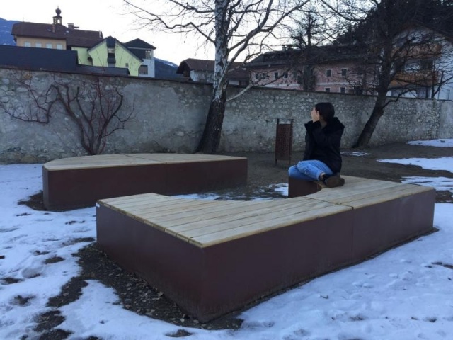 euroform w - Stadtmobiliar - Sitzbank aus Holz und Cortenstahl auf öffentlichem Platz - Parkbank ohne Rückenlehne - Menschen auf Sitzinsel in Innenhof im Grünen - Isola