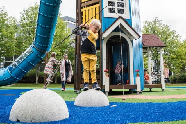 Spielplatz - Lappset - Moomins gigantisches Spielhaus auf Wiese mit Kindern – Freizeitpark Moomins in öffentlichem Park mit Kindern