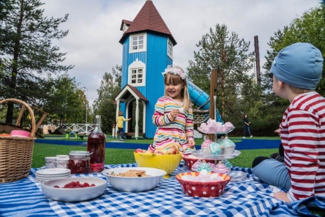 Spielplatz - Lappset - Moomins gigantisches Spielhaus auf Wiese mit Kindern – Freizeitpark Moomins in öffentlichem Park mit Kindern