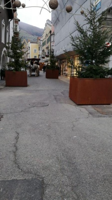 euroform w - Stadtmobiliar - große Pflanzschale aus Metall auf Dorfplatz - riesige Pflanzschale mit Blumen und Baum in urbanem Raum - Pflanzschale aus Cortenstahl