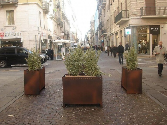 euroform w - Stadtmobiliar - große Pflanzschale aus Metall auf Dorfplatz - riesige Pflanzschale mit Blumen und Baum in urbanem Raum - Pflanzschale aus Cortenstahl