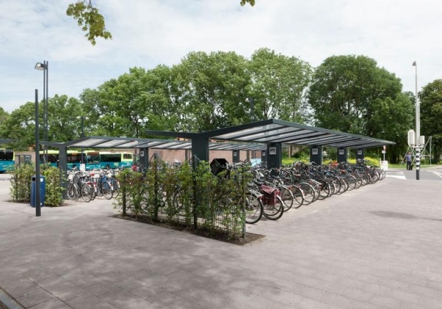 euroform w - Freiraummobiliar - Klaver - Fahrradüberdachung aus Stahl und Glas - Fahrradständer mit Fahrrädern auf öffentlichem Platz