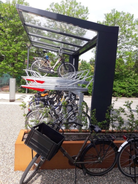 euroform w - Freiraummobiliar - Klaver - Fahrradüberdachung aus Stahl und Glas - Doppelstöckiger Fahrradständer mit Fahrrädern auf öffentlichem Platz