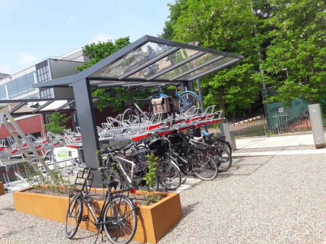 euroform w - Freiraummobiliar - Klaver - Fahrradüberdachung aus Stahl und Glas - Doppelstöckiger Fahrradständer mit Fahrrädern auf öffentlichem Platz