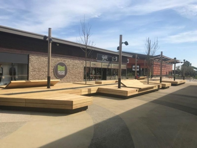 euroform w - sustainable street furniture - seating island in shopping centre - modular seating with shade sail, trees and water - wooden lounger with shade dispenser - bench with indirect lighting