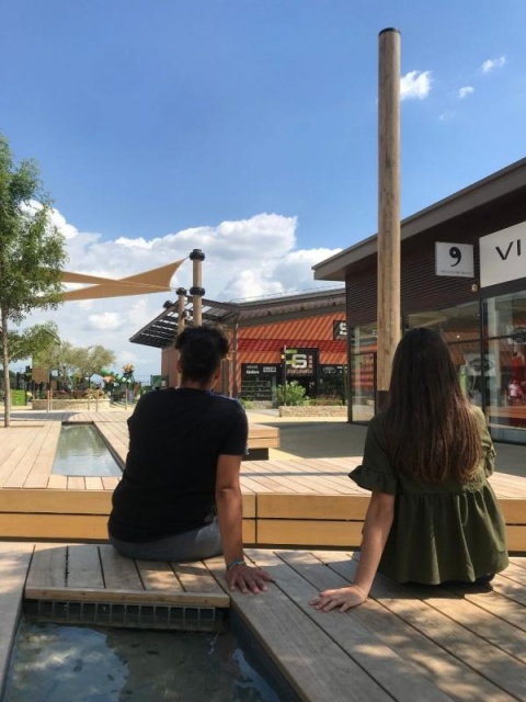 euroform w - sustainable street furniture - seating island in shopping centre - modular seating with shade sail, trees and water - wooden lounger with shade dispenser - bench with indirect lighting