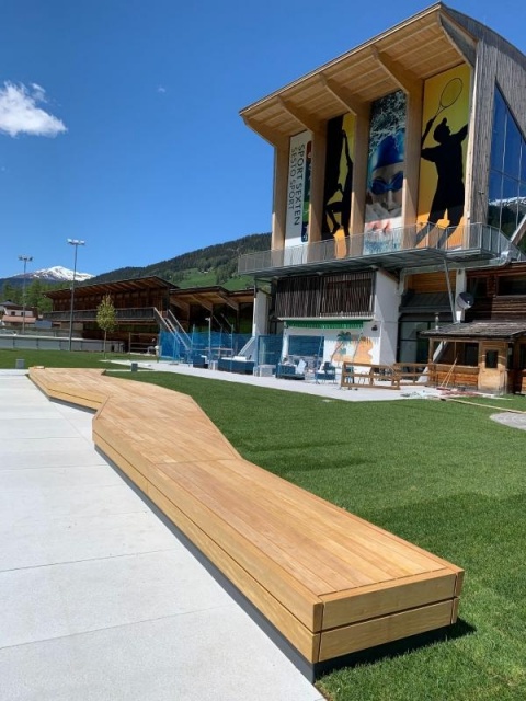 euroform w - Stadtmobiliar - Bank Isola aus Holz im Freibad Sexten mit Blick auf Dolomiten - Sitzbank in Freibad Sexten - Parkbank aus Holz mit Blick auf Dolomiten