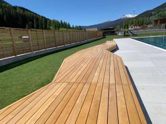 euroform w - Stadtmobiliar - Bank Isola aus Holz im Freibad Sexten mit Blick auf Dolomiten - Sitzbank in Freibad Sexten - Parkbank aus Holz mit Blick auf Dolomiten