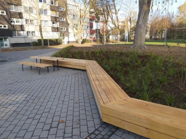 euroform w - street furniture - long angled bench made of wood on city square - designer bench made of wood for outside - wooden seating island for urban space - Isola high quality street furniture