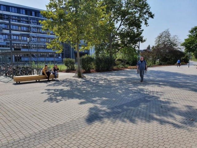 euroform w - street furniture - long angled bench made of wood on city square - designer bench made of wood for outside - wooden seating island for urban space - Isola high quality street furniture