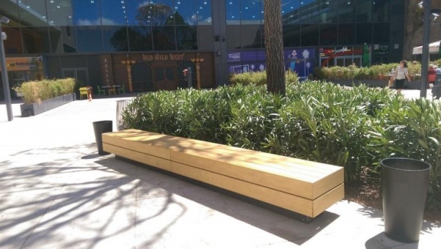 euroform w - street furniture - long angled bench made of wood on city square - designer bench made of wood for outside - wooden seating island for urban space - Isola high quality street furniture