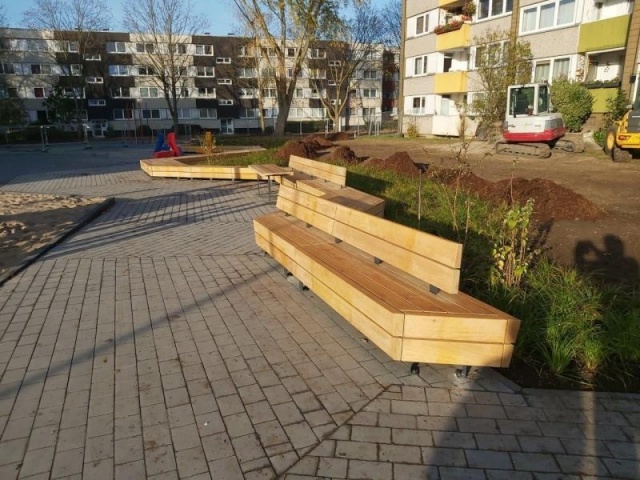 euroform w - Stadtmobiliar - lang gewinkelte Bank aus Holz auf Stadtplatz - Designerbank aus Holz für draußen - Sitzinsel aus Holz für städtischen Raum - Isola IIII hochwertige Stadtmöbel