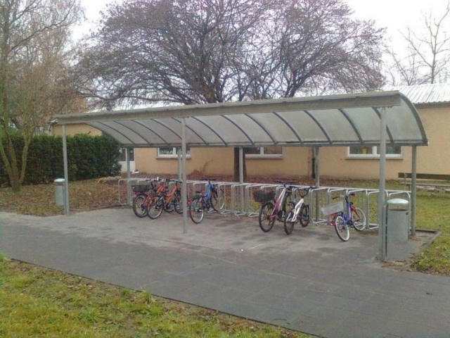 euroform w - Stadtmobiliar - Fahrradständer mit Überdachung bei Wohnkomplex - Wing Bike Fahrraddepot - Fahrradüberdachung aus Glas und Metall