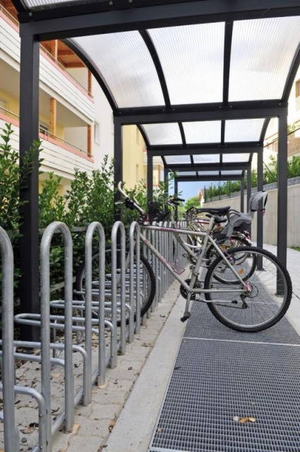 euroform w - Stadtmobiliar - Fahrradständer mit Überdachung bei Wohnsiedlung in Südtirol - Galleria Überdachung aus Metall und Glas