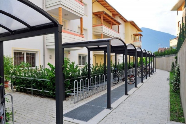 euroform w - Stadtmobiliar - Fahrradständer mit Überdachung bei Wohnsiedlung in Südtirol - Galleria Überdachung aus Metall und Glas