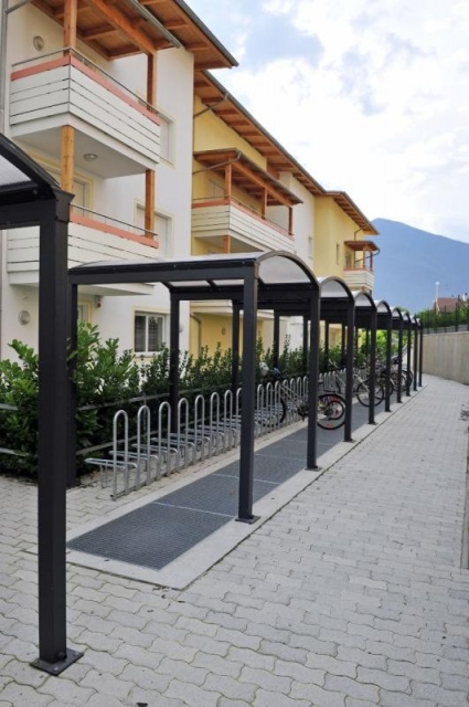 euroform w - Stadtmobiliar - Fahrradständer mit Überdachung bei Wohnsiedlung in Südtirol - Galleria Überdachung aus Metall und Glas