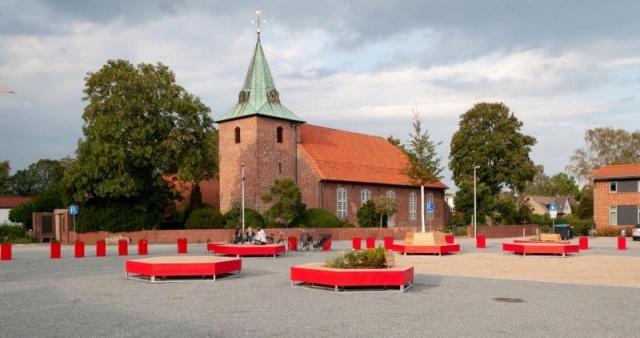 euroform w - Stadtmobiliar - eckige Bank aus Holz und buntem Metall auf öffentlichem Platz in Weyhe - Sitzinsel für den öffentlichen Raum - Bank mit Baum in Mitte - customized Stadtmöbel  für Weyhe Deutschland