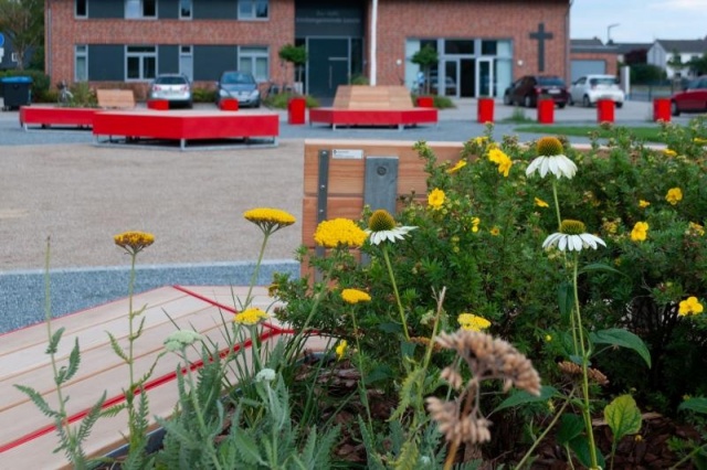 euroform w - arredo urbano - panchina angolare in legno e metallo colorato sulla piazza pubblica di Weyhe - isola di seduta per lo spazio pubblico - arredo urbano personalizzato per Weyhe Germania - Panchina fioriera con albero nel mezzo