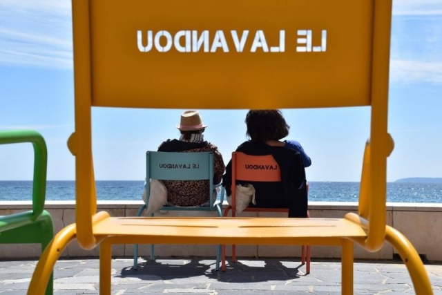 euroform w - Stadtmobiliar - Menschen sitzen auf bunten Stühlen und Hockern aus Metall mit Blick auf das Meer - bunte Stühle entlang der Promenade in Le Lavandou an der Cote d