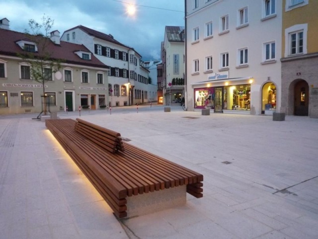 euroform w - Stadtmobiliar - minimalistische Bank aus Holz und Beton mit indirekter Beleuchtung bei Wiltener Platzl in Innsbruck - Sitzinsel aus Holz und Beton auf öffentlichem Platz in Österreich - customized Stadtmöbel - Sonderlösung für den urbanen Rau