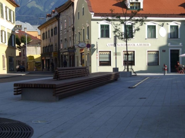 euroform w - Stadtmobiliar - minimalistische Bank aus Holz und Beton mit indirekter Beleuchtung bei Wiltener Platzl in Innsbruck - Sitzinsel aus Holz und Beton auf öffentlichem Platz in Österreich - customized Stadtmöbel - Sonderlösung für den urbanen Rau