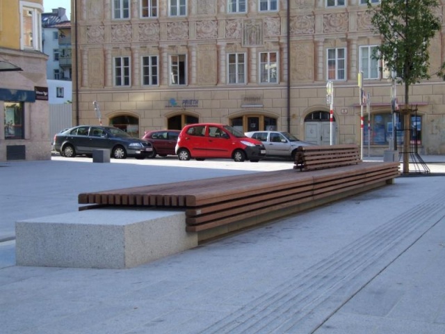 euroform w - Stadtmobiliar - minimalistische Bank aus Holz und Beton mit indirekter Beleuchtung bei Wiltener Platzl in Innsbruck - Sitzinsel aus Holz und Beton auf öffentlichem Platz in Österreich - customized Stadtmöbel - Sonderlösung für den urbanen Rau