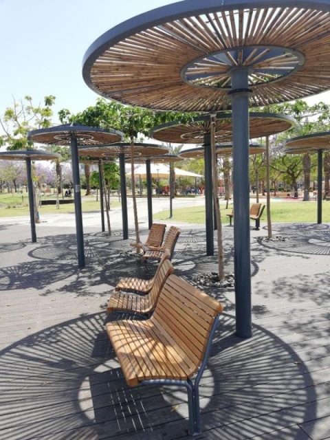 euroform w - street furniture - bench and seating made of wood on public square in Tel Aviv - cosy rest area with shade trees and chairs in park in Tel Aviv, Israel - Contour Bench