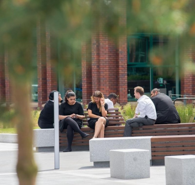 euroform w - Stadtmobiliar - minimalistische Bank aus Holz und Beton auf öffentlichem Platz in England - Sitzinsel aus Holz für draußen - customized Stadtmöbel