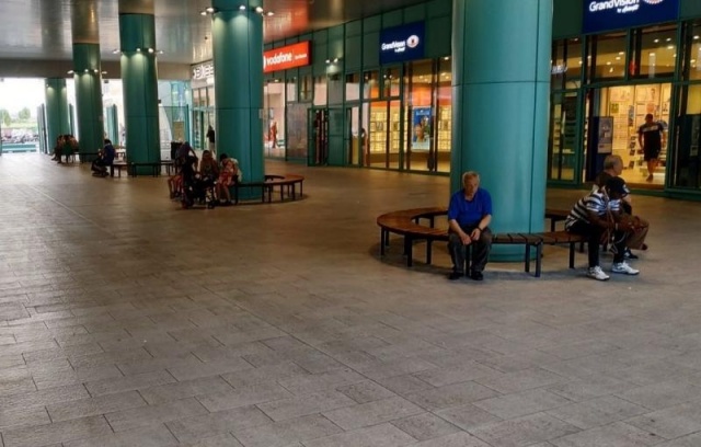 euroform w - Arredo urbano - Persone sedute su una panchina circolare in legno in centro commerciale a Firenze - Panchina per spazio pubblico - arredo urbano personalizzato