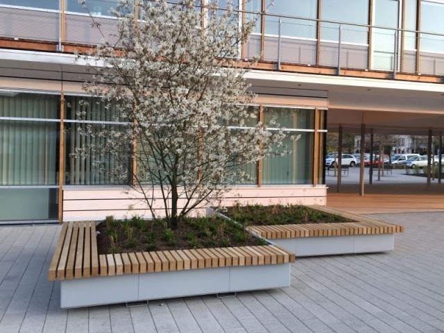 euroform w - Street furniture - Bench made of wood with integrated metal planter in Prien am Chiemsee - Seating island made of wood and metal with tree - big planter with seating platform for public space - customized street furniture