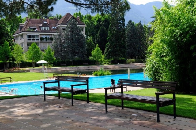 euroform w - street furniture - Bench made of wood in outdoor pool Therme Meran - seating Quattro in front of architectural building - Bench for senior citizens for outdoor use
