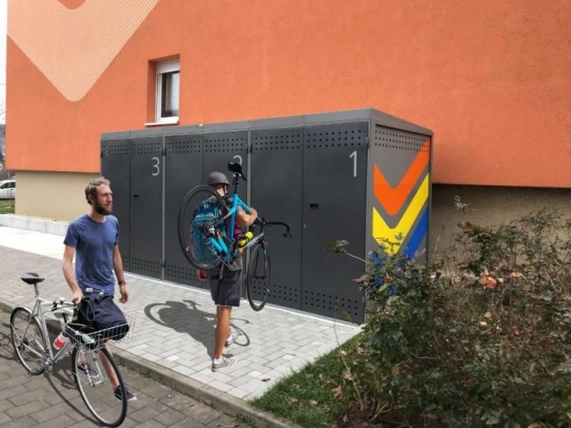 euroform w - urban furniture - men with bike at bike storage with locking system - customized bike box - safely biking your bicycle