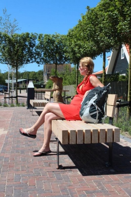 euroform w - arredo urbano - donna su panchina in centro città in Ollanda - seduta in legno sostenibile - panchina su misura